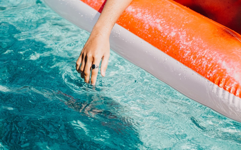 woman relaxes on a floatie in swimming pool