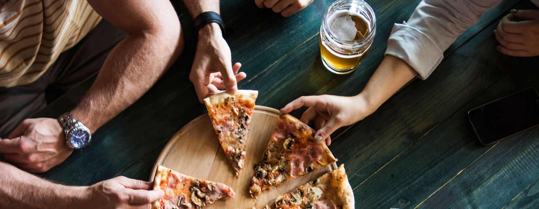 a group of people eating pizza